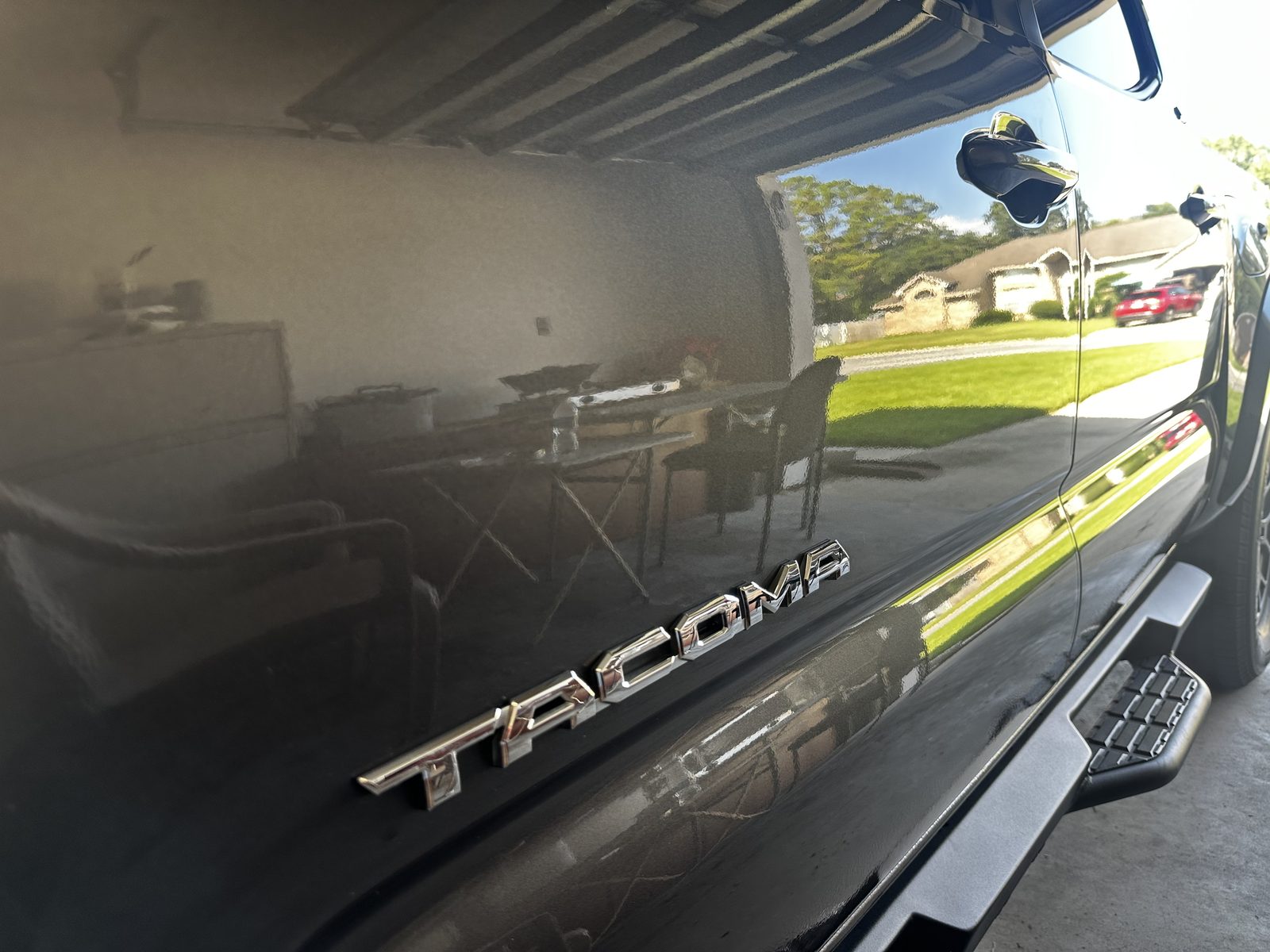 Close-up of a polished Toyota Tacoma badge with a mirror-like reflective shine